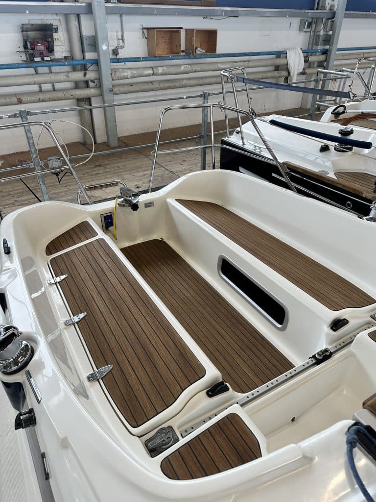 Heck der SUNBEAM 29KS Yacht mit Holzboden und Sitzbereichen im Inneren der Werkhalle.