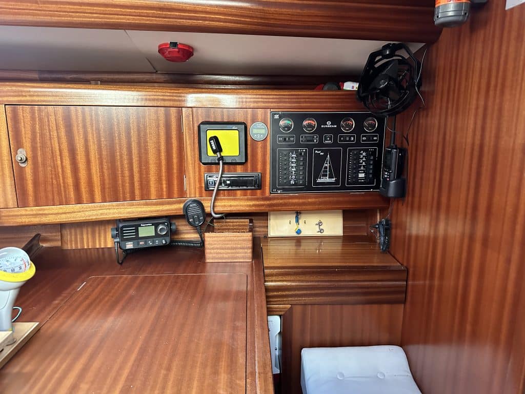 Navigationsbereich der SUNBEAM 39 mit Kartenplotter, Schaltpanel und VHF-Funkgerät, integriert in eine Holzkonsole.