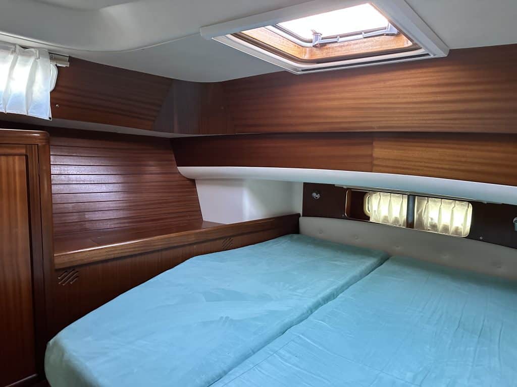 Schlafkabine der SUNBEAM 39 Yacht mit Doppelbett, Holzschränken und Oberlicht für Tageslichteinfall.