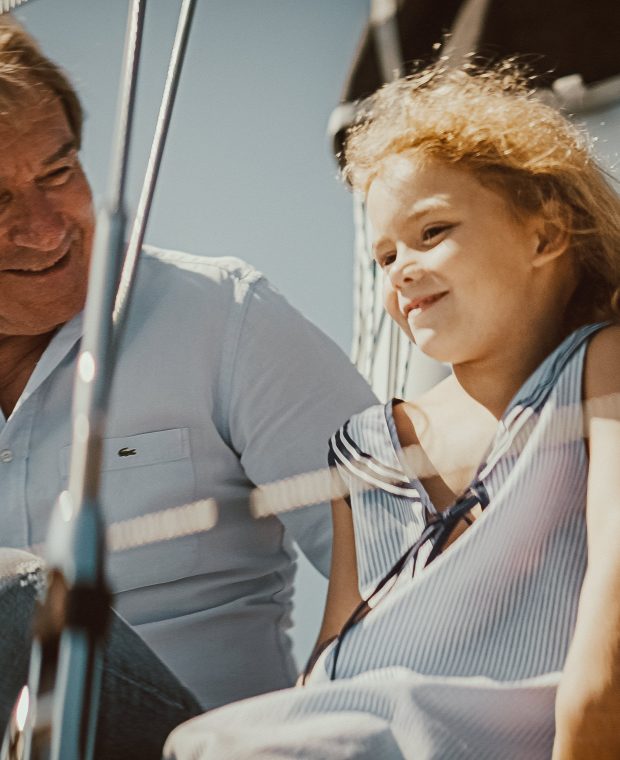 Ein lächelnder Erwachsener und ein glückliches Kind in Freizeitkleidung teilen einen Moment auf einer Sunbeam Yacht