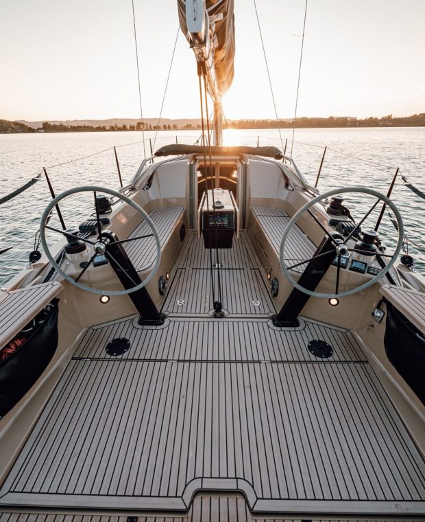 Steuerstand einer Sunbeam Yacht im Hafen bei Sonnenuntergang, mit einem Fokus auf das sauber verlegte Deck