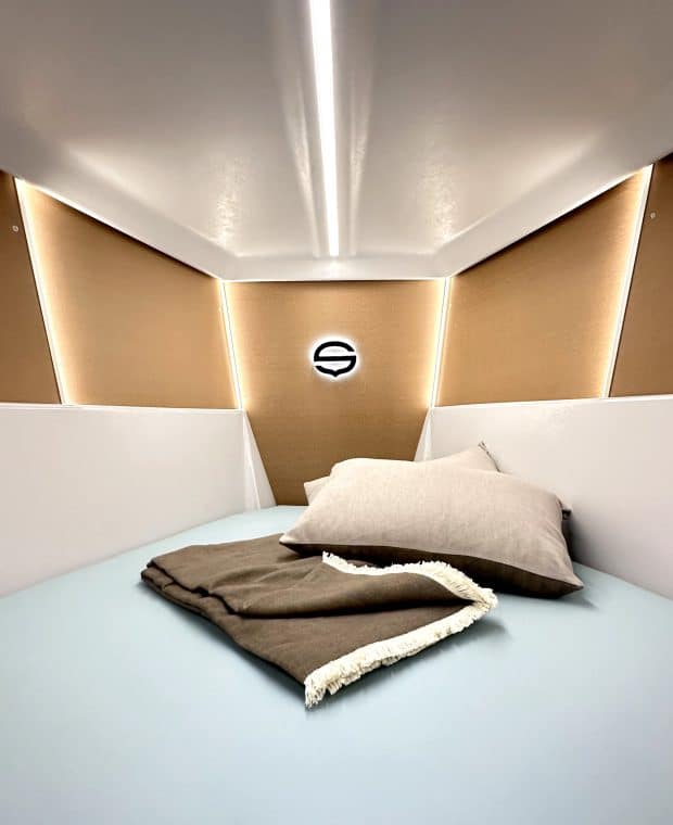 Gemütliche Bugkabine einer Sunbeam 29.1 mit einem großen V-Bett, ausgestattet mit hellblauer Bettwäsche und einem zusammengerollten braunen Deckenschlafsack.